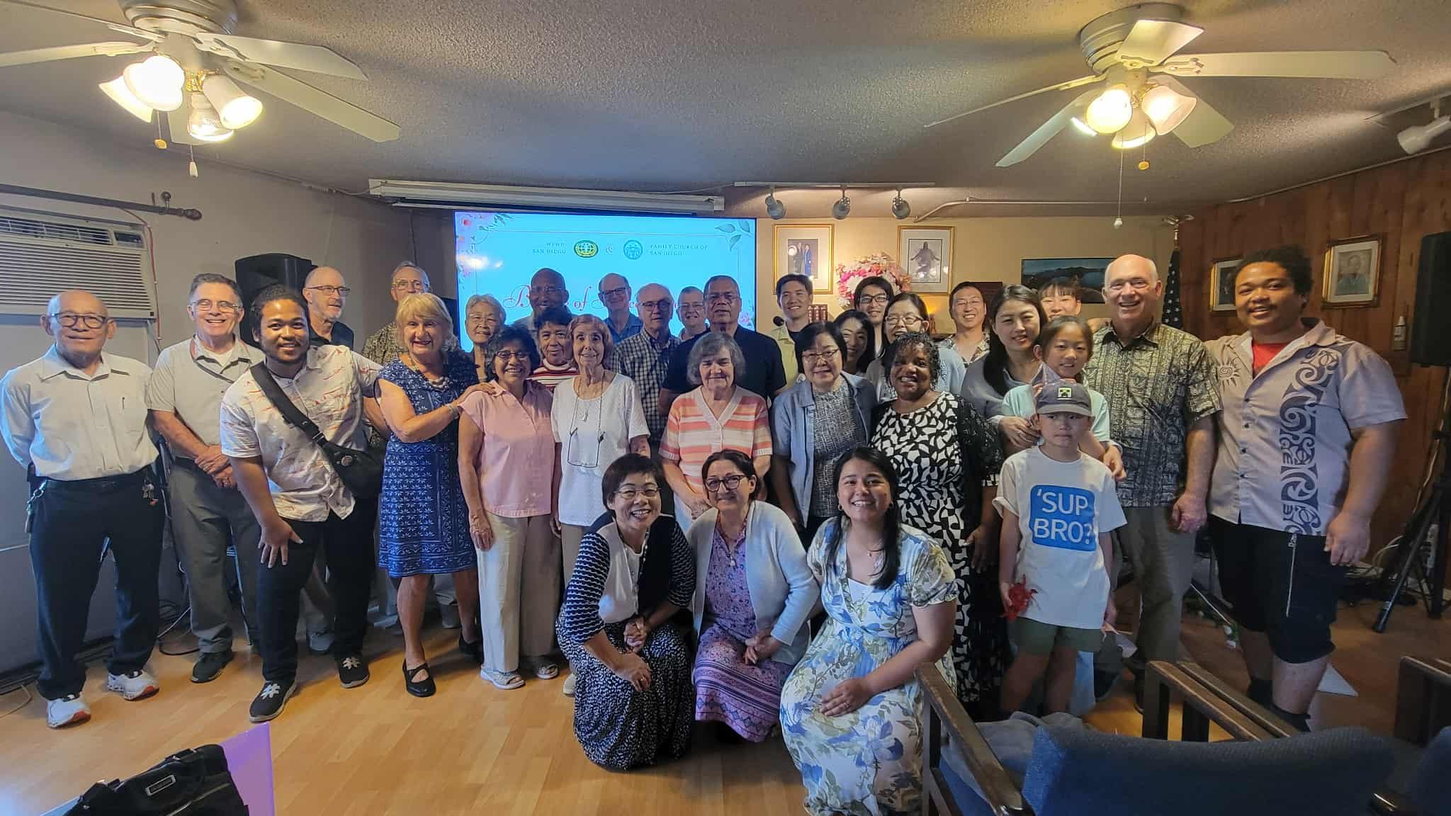 Church members of every age standing together for a group photo in the sanctuary