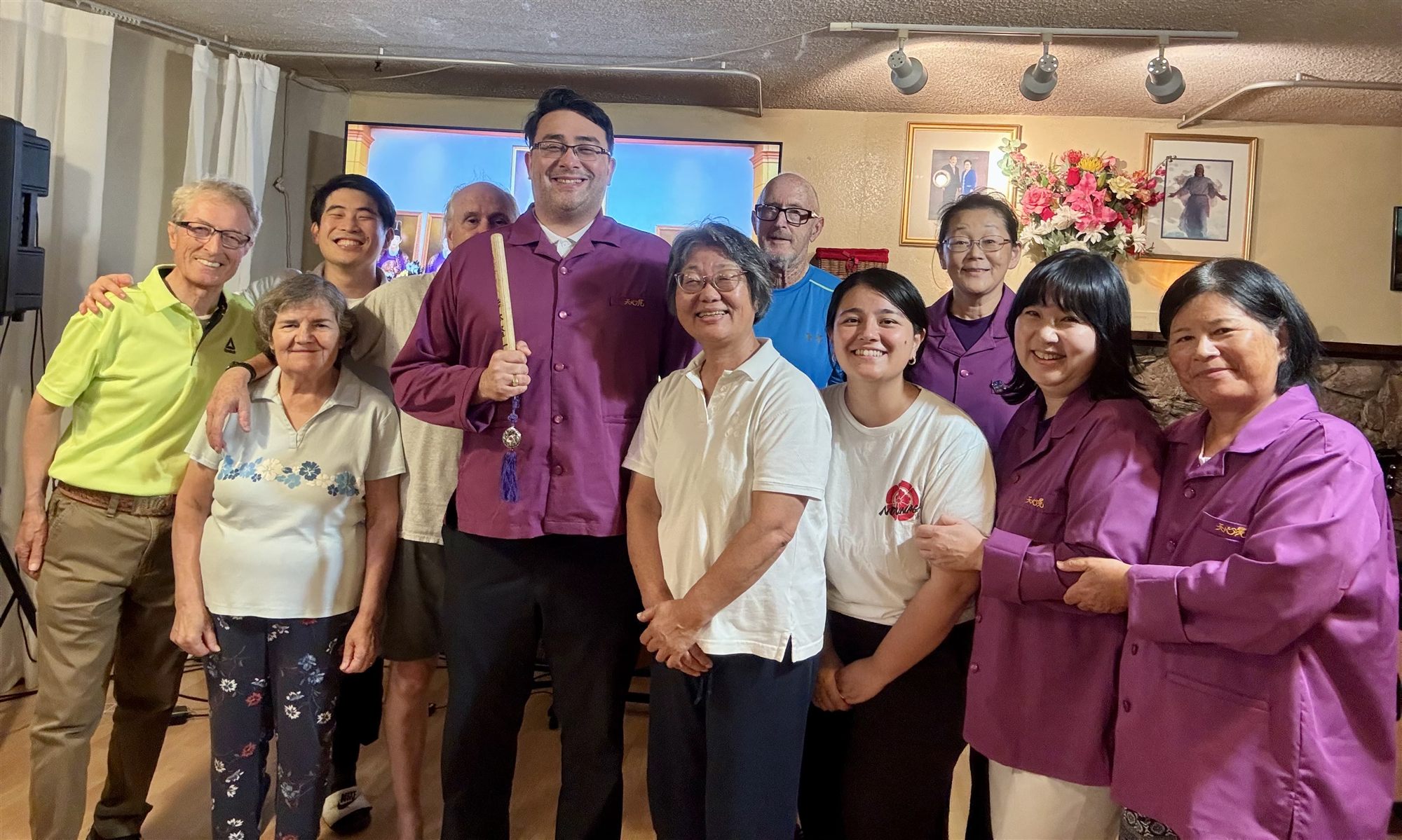 Church members, several in matching purple jackets, standing together in the sanctuary