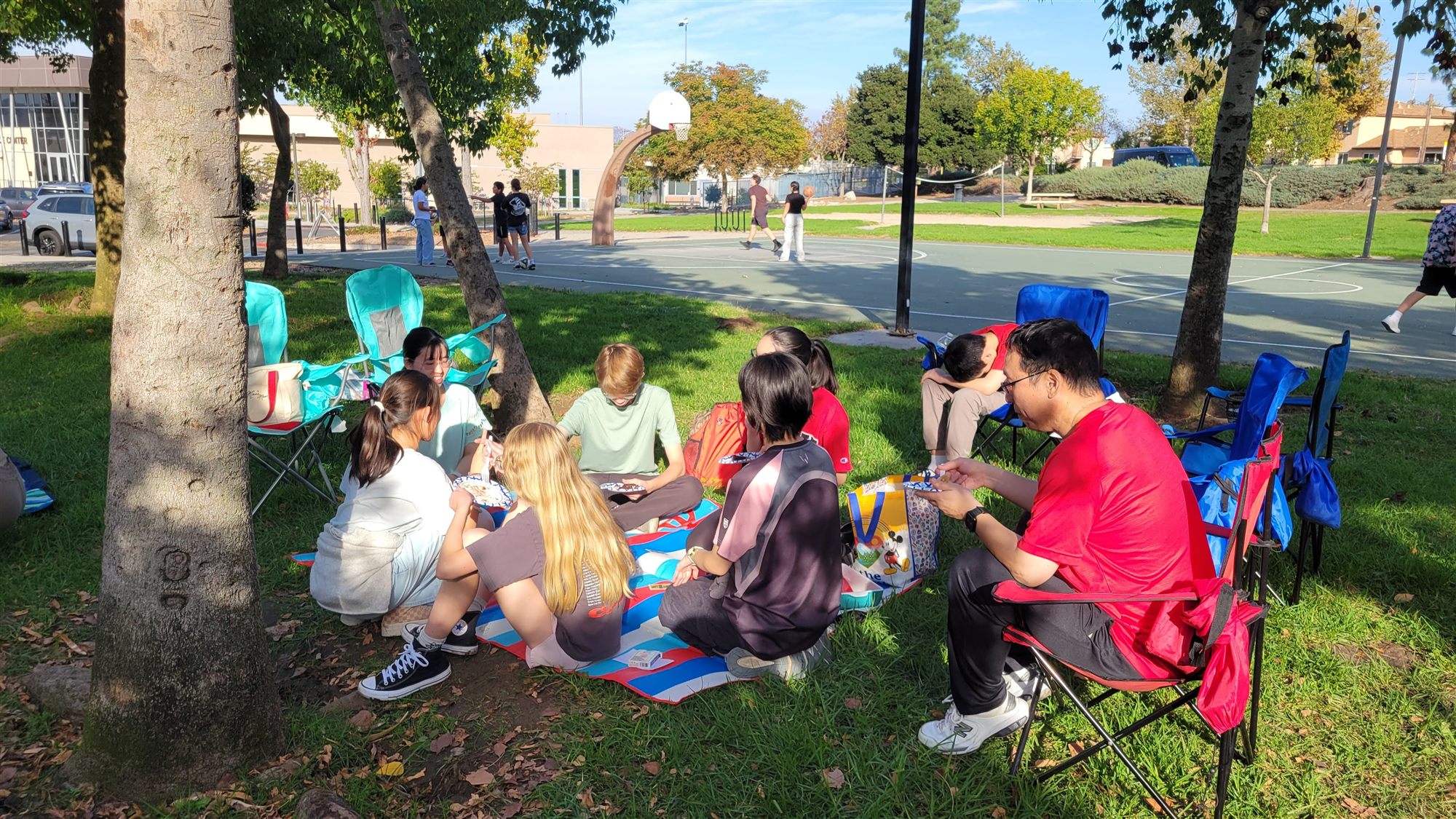 Children sharing snacks on a picnic blanket in the park